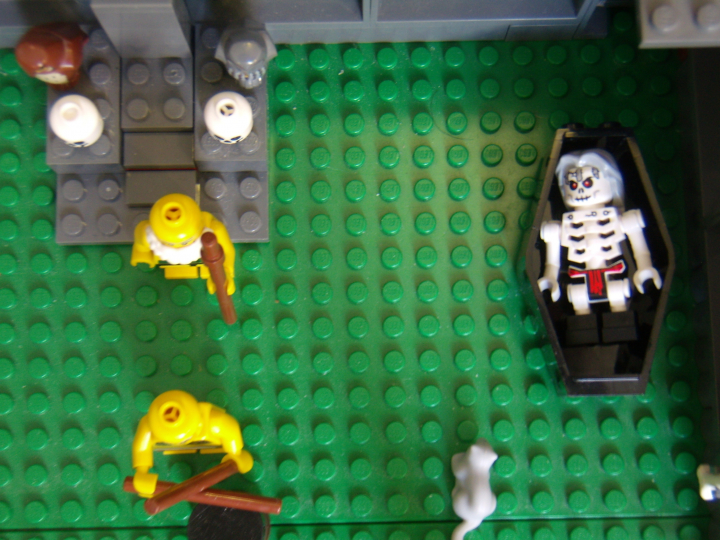 LEGO MOC - Because we can! - Caveman fire discovery: Трон старейшины, на подлокотниках которого сидят мудрые совы, видны черепа и целый скелет предшествующих старейшин. Старейшина клана древних людей. Вид сверху.