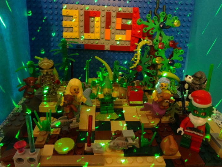 LEGO MOC - New Year's Brick 3015 - Подводная страна встречает Новый год. : Новогодняя вечеринка на дне океана, на которой собрались подводные обитатели. Русалочки позвали своих друзей- видоизменённого человека и подводного жука. Они водили хоровод и вот в 12 часов ночи приплывает болотный Дед Мороз и дарит им подарки. Под ёлку Мороз положил коробку с подарком. Её получит эльф, который скоро приплывёт. 