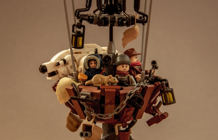 LEGO MOC - LEGO-конкурс 16x16: 'Иллюстрация' - На воздушном шаре: <br>Понемногу дыхание и сердцебиение у Лиры успокоились, и к ней вернулось душевное равновесие. Она села и огляделась.<br><br />
Корзина оказалась гораздо больше, чем она думала. Вдоль бортов тянулись полки с философскими приборами, на дне лежали груды мехов, баллоны с воздухом и еще какие-то предметы непонятного назначения или настолько мелкие, что туман не позволял их разглядеть.<br><br />
– Мы в туче? – спросила она.<br><br />
– Ну да. Накрой-ка своего друга мехом, пока он не превратился в сосульку. Холодно, а будет еще холодней.<br><br />
– Как вы нашли нас?<br><br />
– Ведьмы. Тут одна дама хочет с тобой потолковать. Вот выйдем из тучи, определимся, и тогда уж сядем, почешем языки.<br>